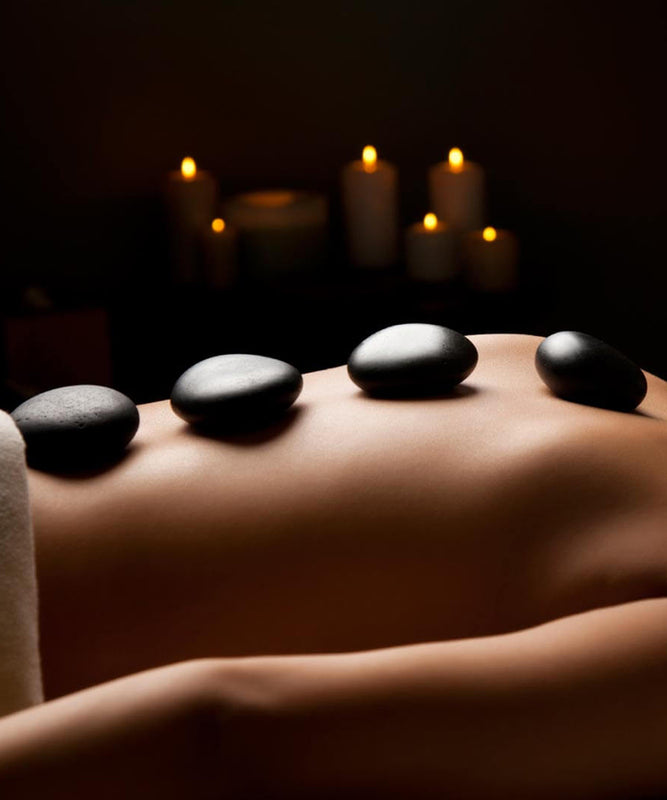 massage with black hot stones on the back