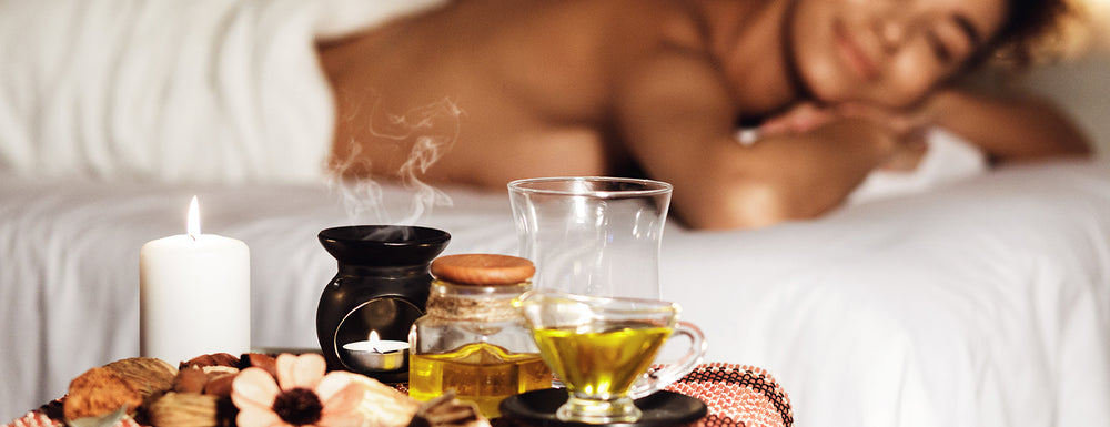 close up banner of focused on oils with aromatherapy massage in the background